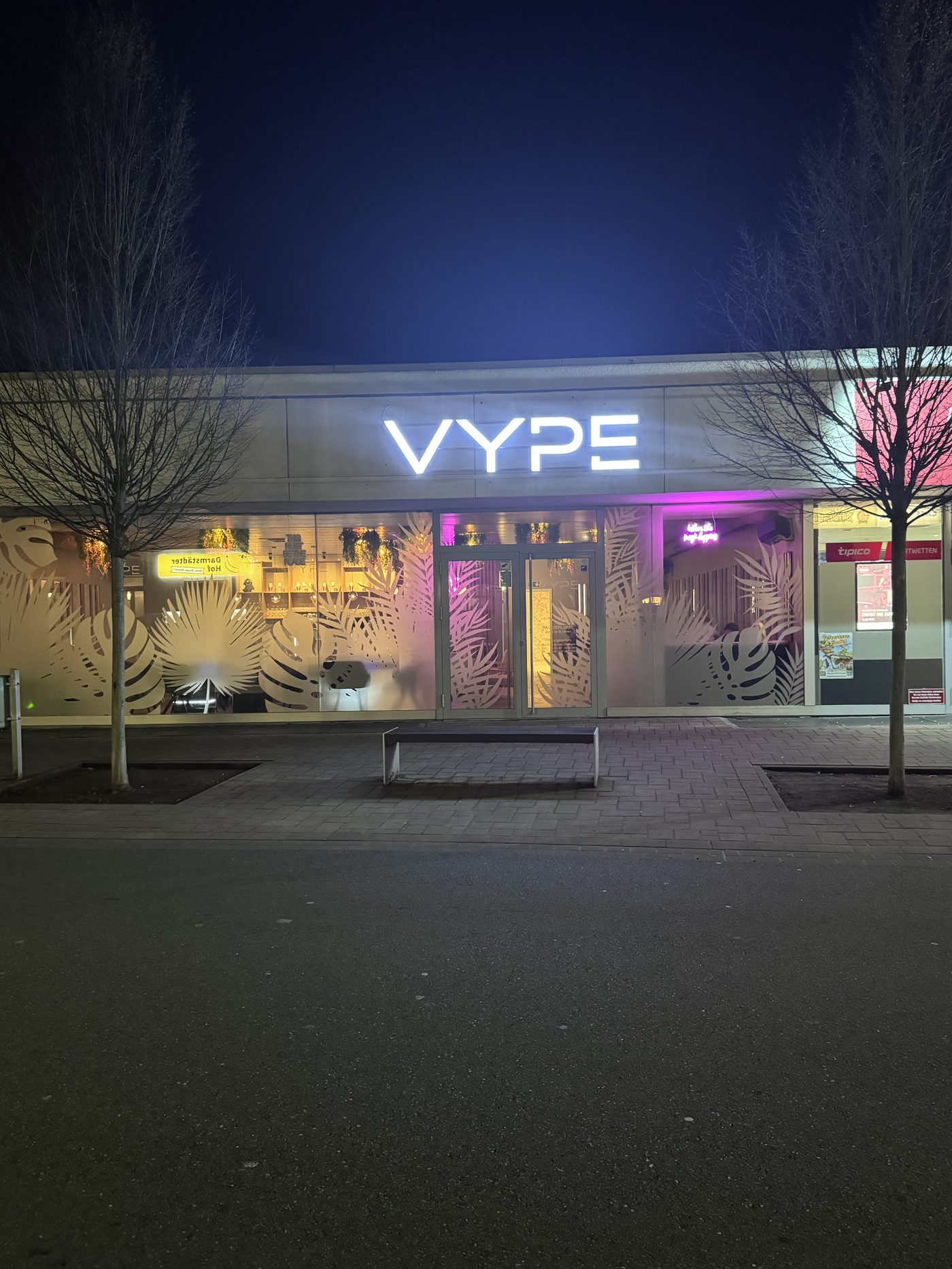 Leuchtschrift VYPE am Eingang bei Nacht