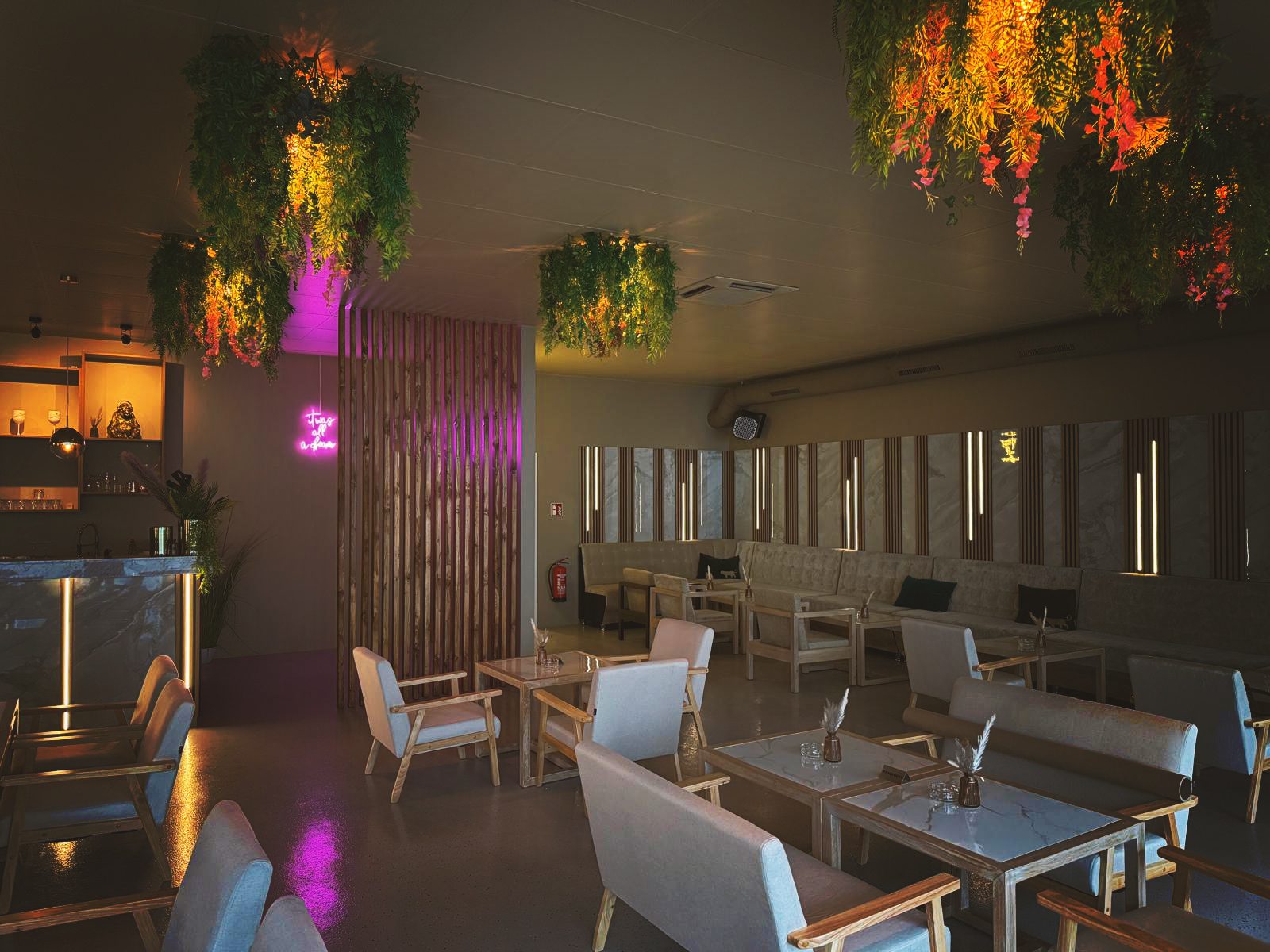 Lounge-Bereich mit hängenden Pflanzen und warmem Licht